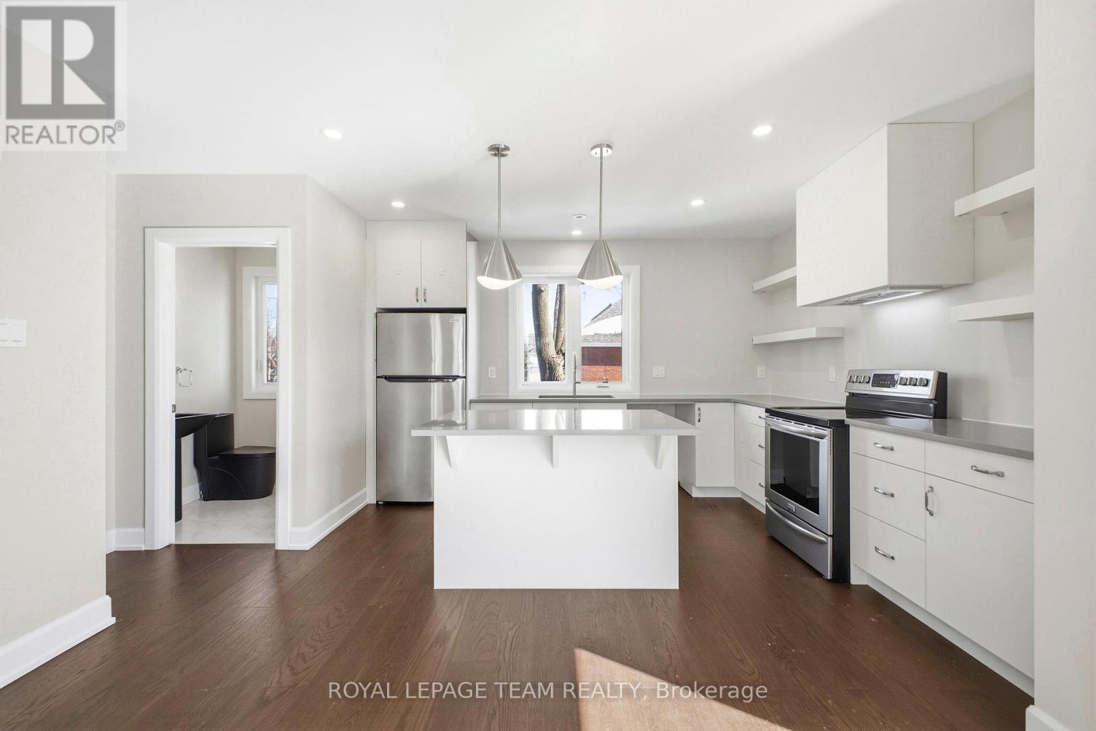 A modern kitchen with white cabinets and stainless steel appliances.