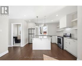 A modern kitchen with white cabinets and stainless steel appliances.
