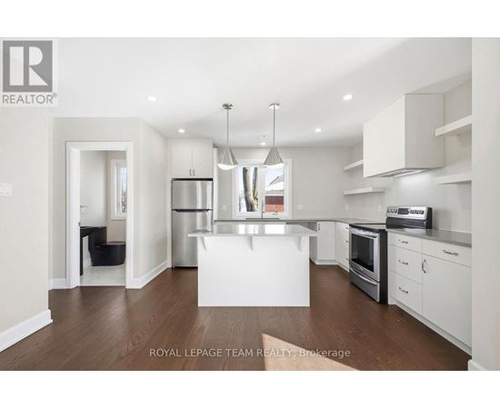 A modern kitchen with white cabinets and stainless steel appliances.