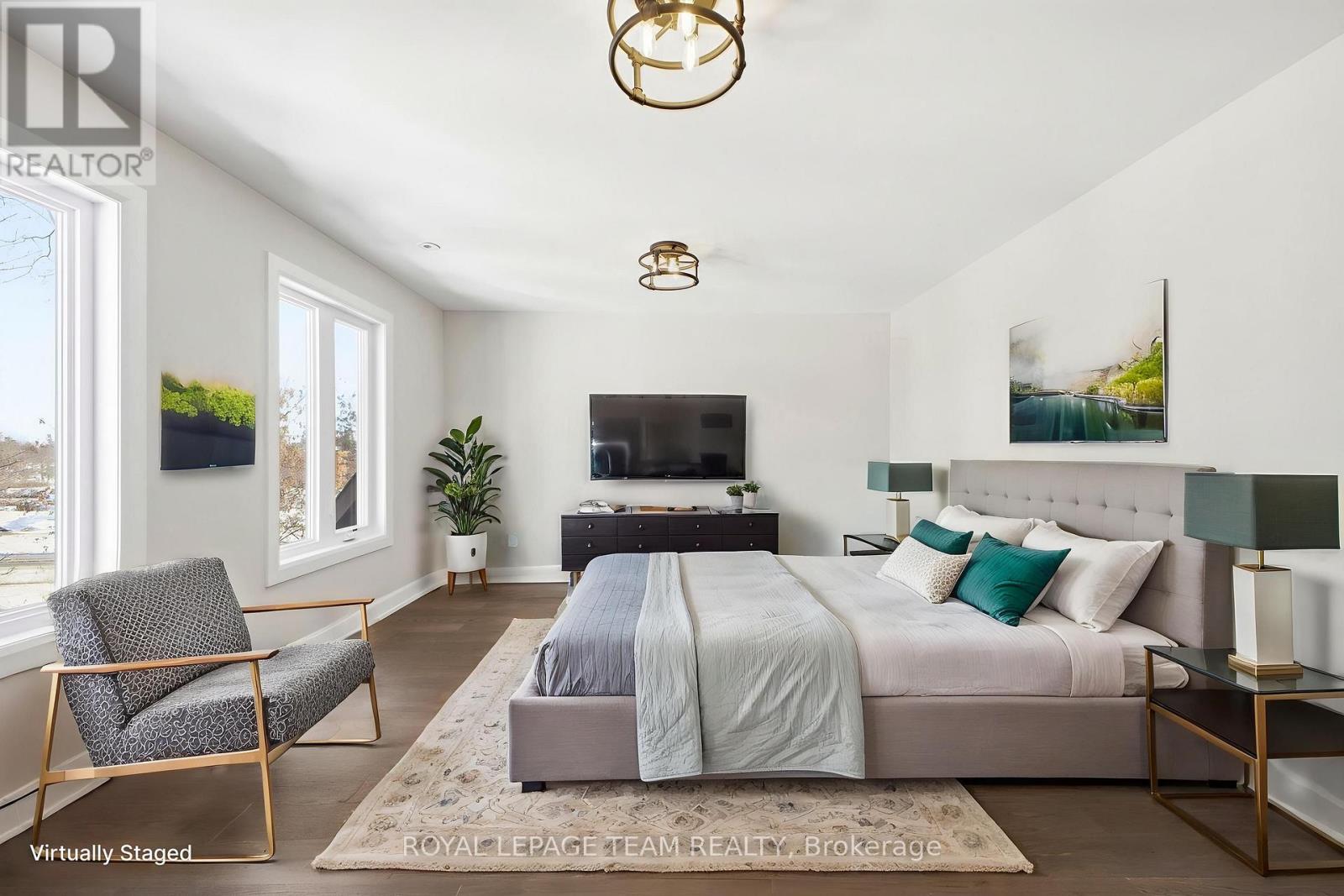 A bedroom with a bed, chair, and a television.