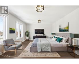 A bedroom with a bed, chair, and a television.