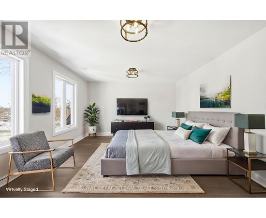 A bedroom with a bed, chair, and a television.