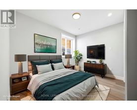 A bedroom with a bed, nightstands, and a painting on the wall.