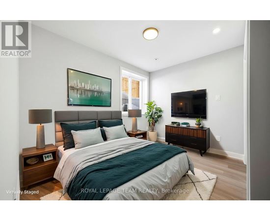A bedroom with a bed, nightstands, and a painting on the wall.