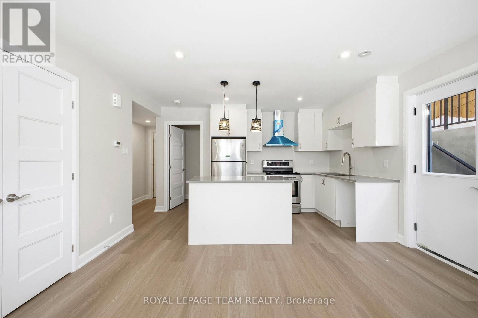A spacious kitchen with white cabinets and a central island.