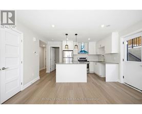 A spacious kitchen with white cabinets and a central island.