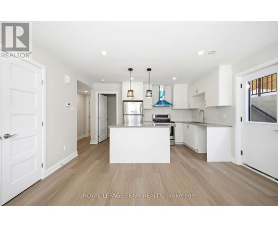 A spacious kitchen with white cabinets and a central island.