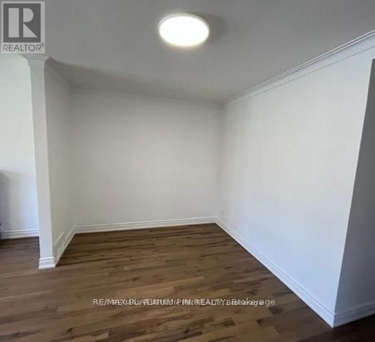 A room with wooden flooring and white walls.