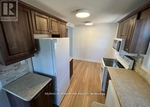 A kitchen with brown cabinets and a white refrigerator.