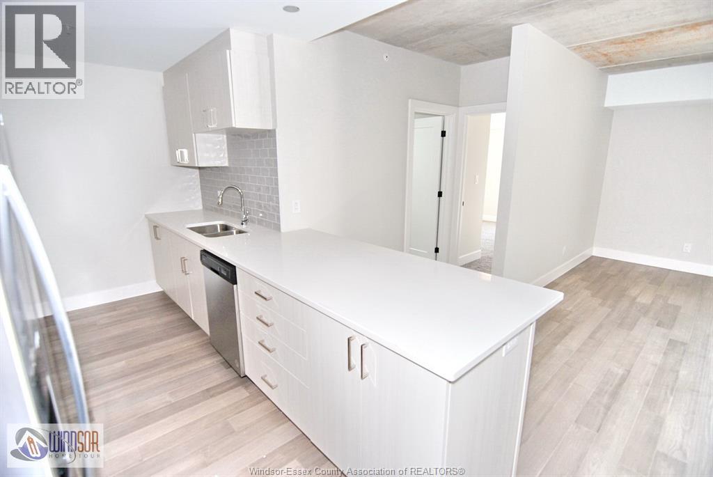 A kitchen with white cabinets and a wooden floor.