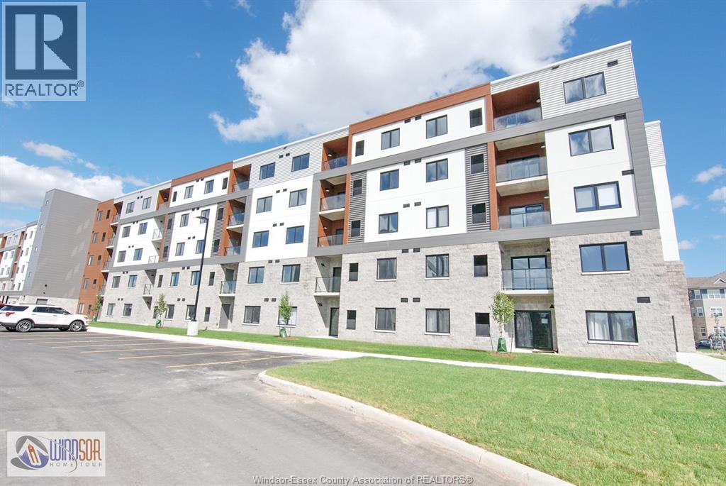A modern apartment building with a parking lot in front.