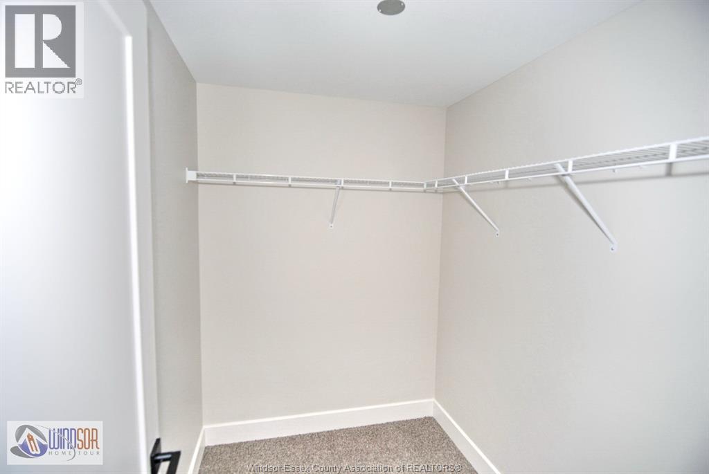 A white bedroom with a bed frame on the wall.