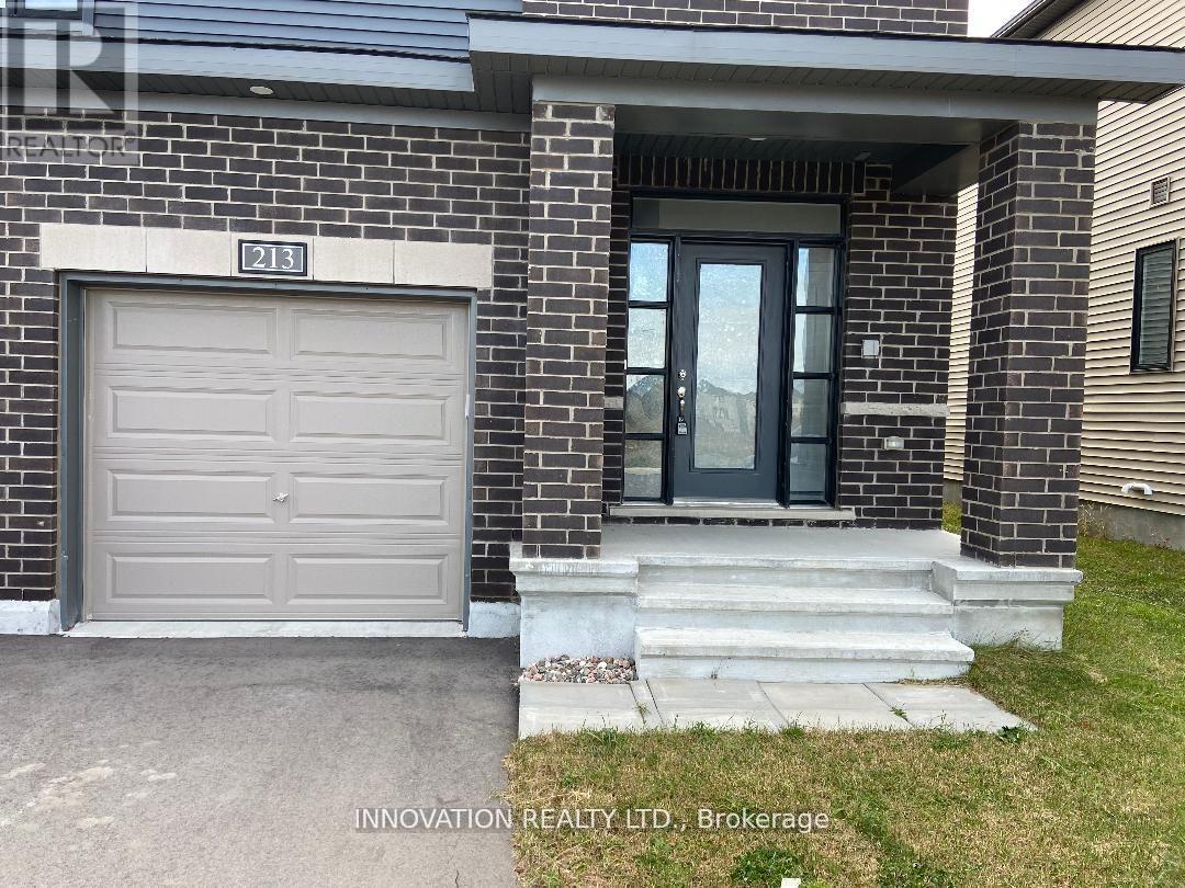 A house with a grey garage door and a glass door entrance.