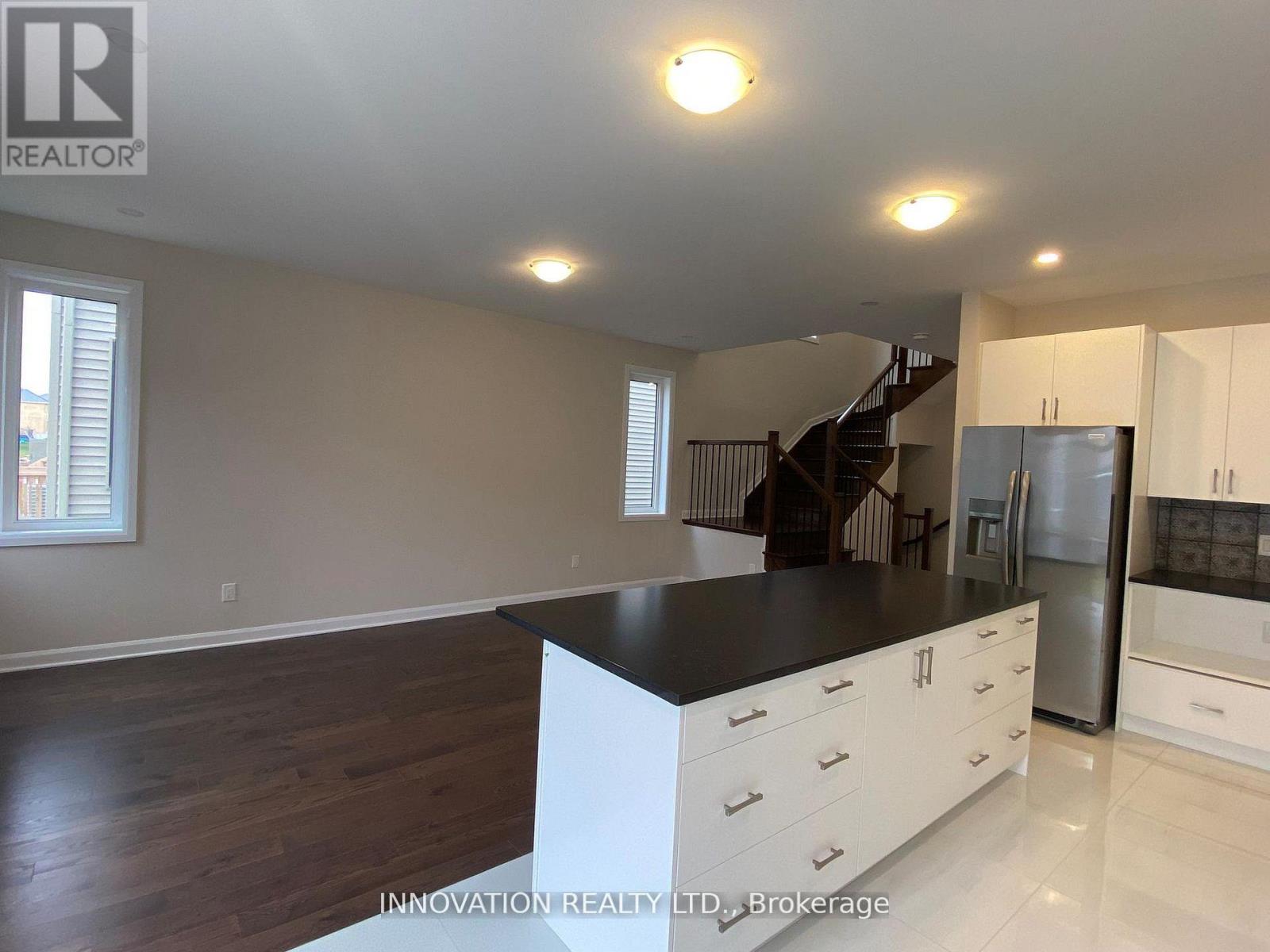 A spacious kitchen with white cabinets and a black countertop.