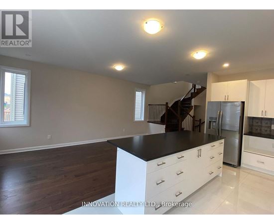 A spacious kitchen with white cabinets and a black countertop.