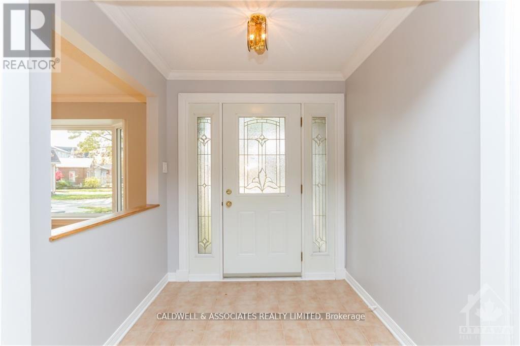 A white door with a glass panel and a chandelier hangs in a hallway.