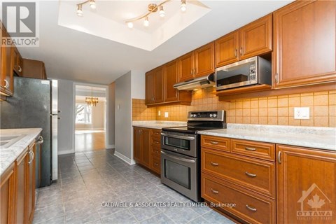 A kitchen with wooden cabinets and a refrigerator.