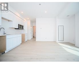 A spacious kitchen with white cabinets and a microwave on the counter.
