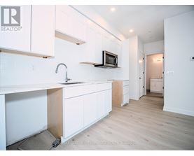 A kitchen with white cabinets and a microwave on the counter.