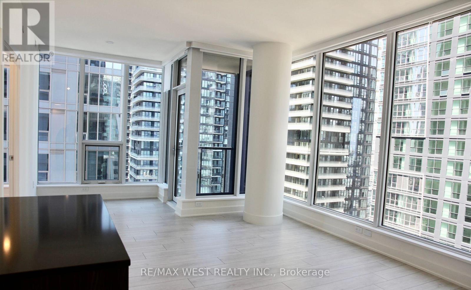 A spacious room with a view of a cityscape through large windows.