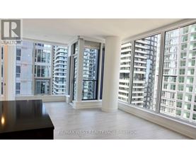 A spacious room with a view of a cityscape through large windows.