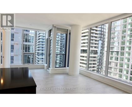 A spacious room with a view of a cityscape through large windows.