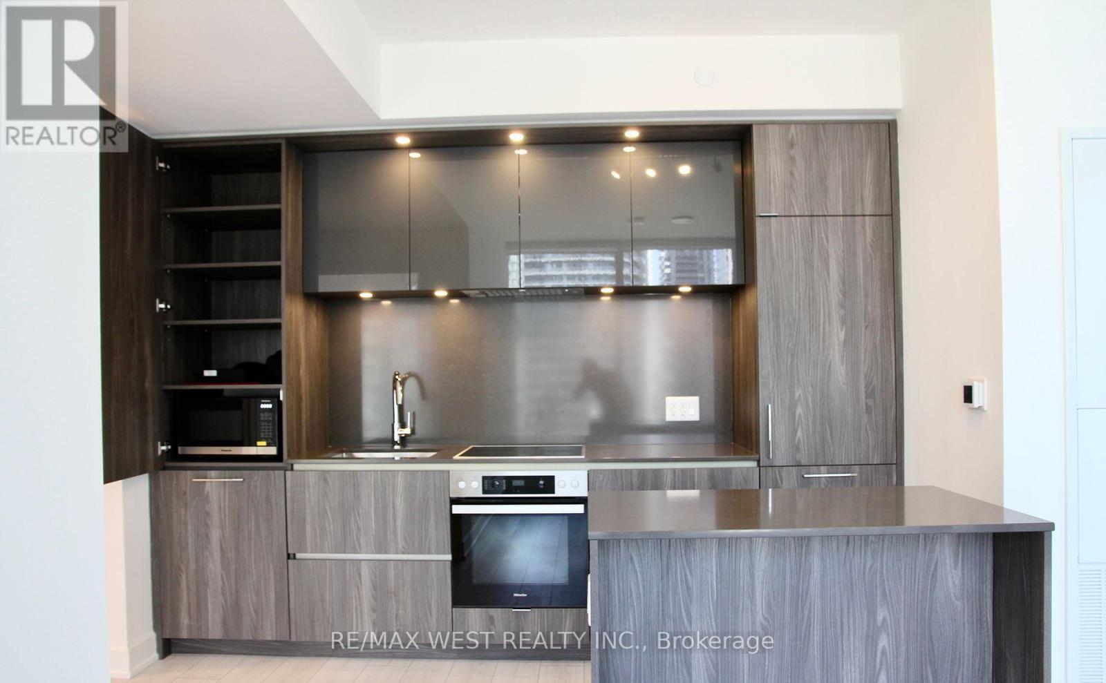 A modern kitchen with a stainless steel oven and wooden cabinets.