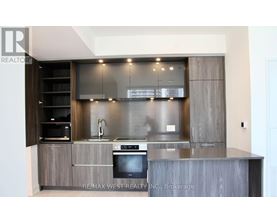 A modern kitchen with a stainless steel oven and wooden cabinets.
