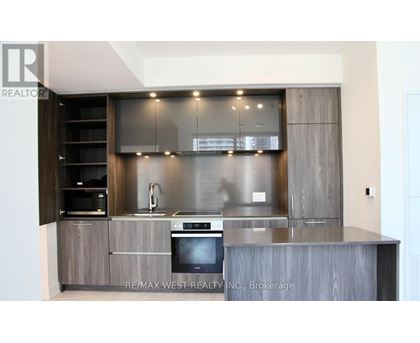 A modern kitchen with a stainless steel oven and wooden cabinets.