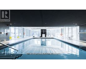A large indoor swimming pool with a logo on the wall.