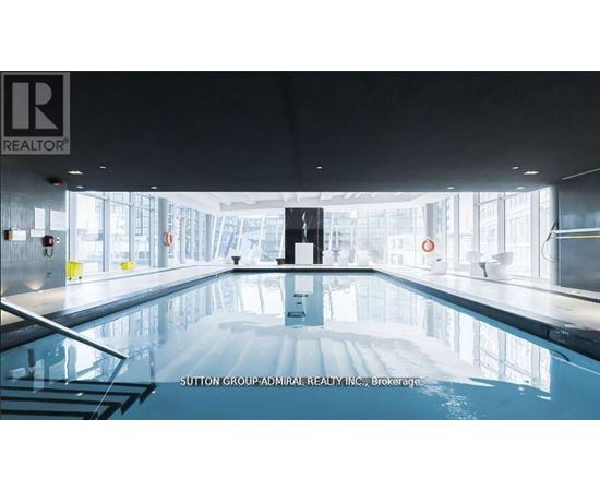 A large indoor swimming pool with a logo on the wall.