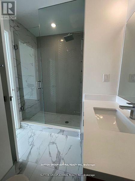 A bathroom with a marble floor and a walk-in shower.