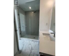 A bathroom with a marble floor and a walk-in shower.