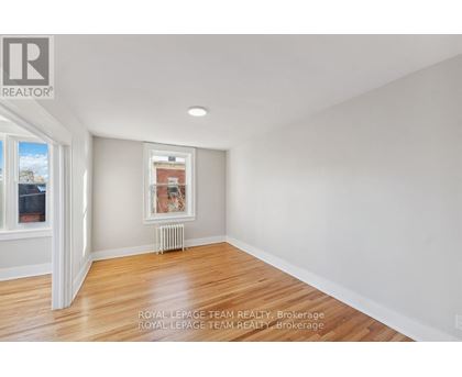 A white room with a window and a picture on the wall.
