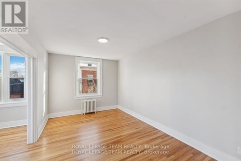 A white room with a window and a picture on the wall.
