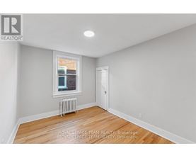 A white room with a window and a radiator.