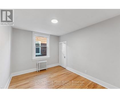 A white room with a window and a radiator.