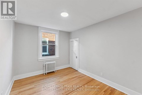 A white room with a window and a radiator.