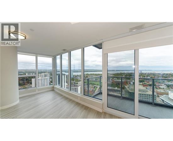 A spacious room with large windows overlooking a cityscape.