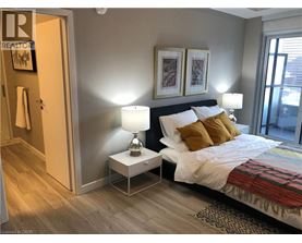 A bedroom with a bed, nightstand, and lamp.