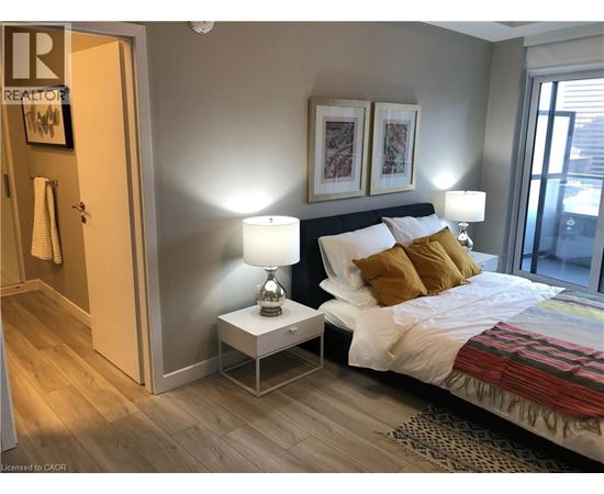A bedroom with a bed, nightstand, and lamp.