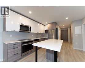 A modern kitchen with a white table and stainless steel appliances.