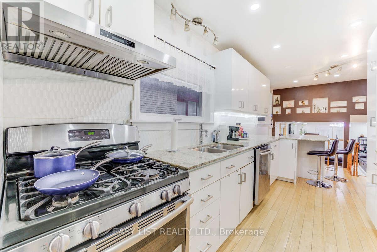 A modern kitchen with a stove top oven and a white color scheme.