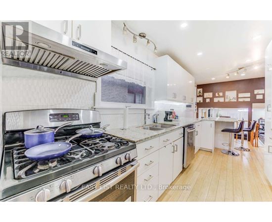 A modern kitchen with a stove top oven and a white color scheme.