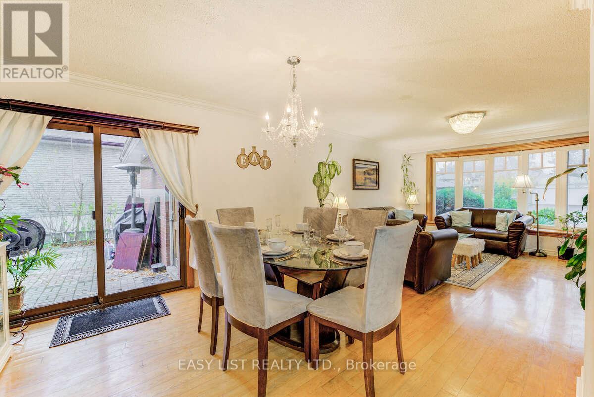 A dining room with a table set for six and a chandelier hanging from the ceiling.