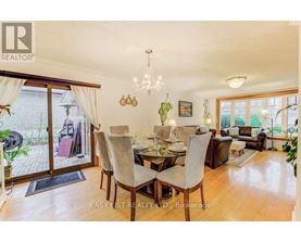 A dining room with a table set for six and a chandelier hanging from the ceiling.