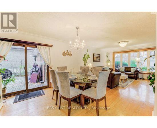 A dining room with a table set for six and a chandelier hanging from the ceiling.