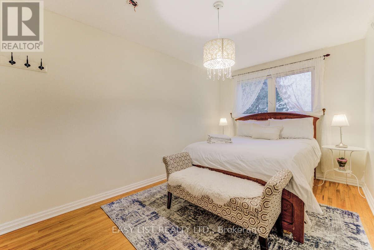 A bedroom with a bed, chair, and window.