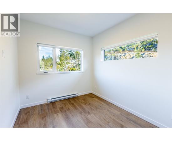 A room with a window showing trees outside.