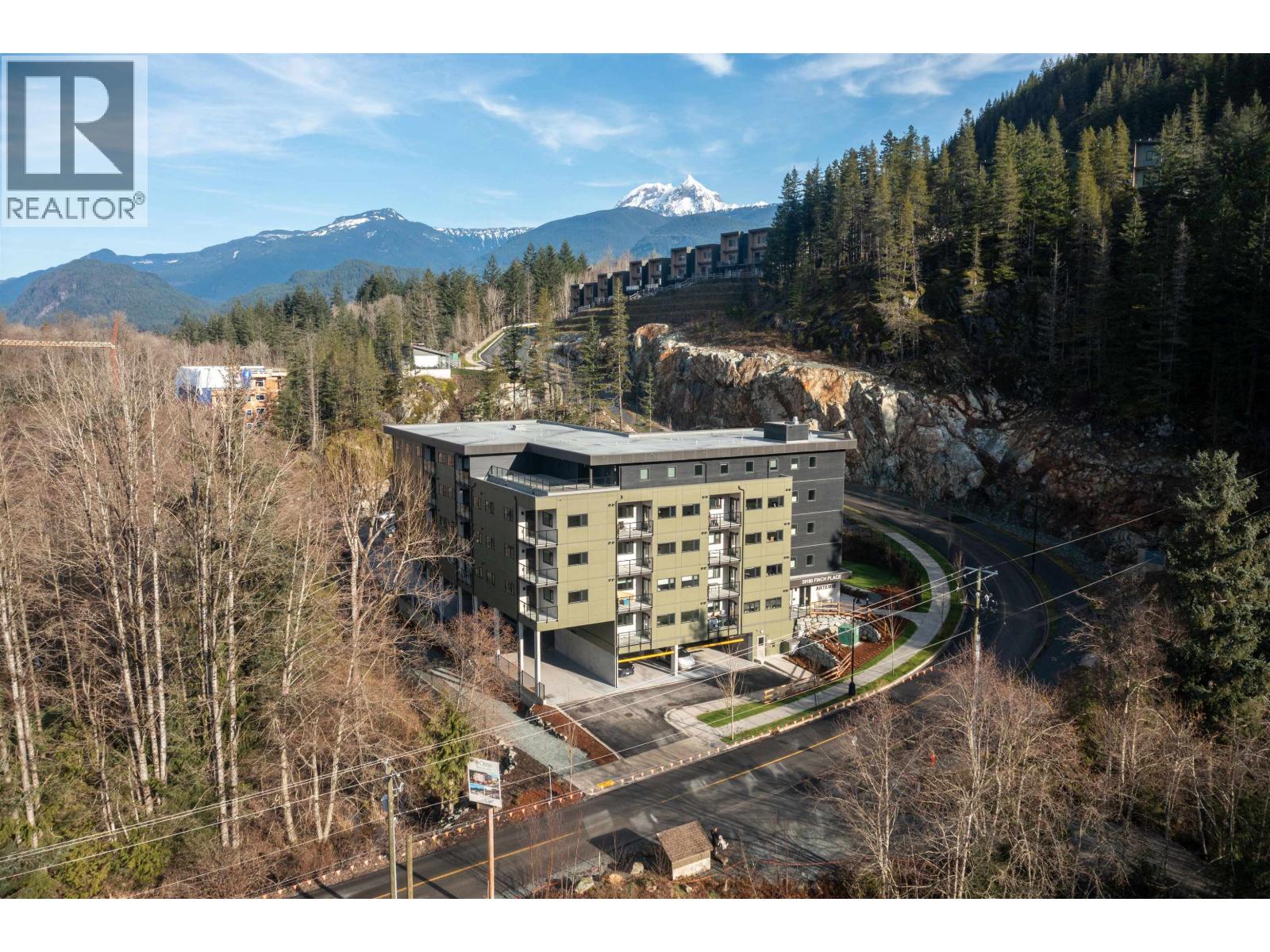 A large building with a mountain in the background.